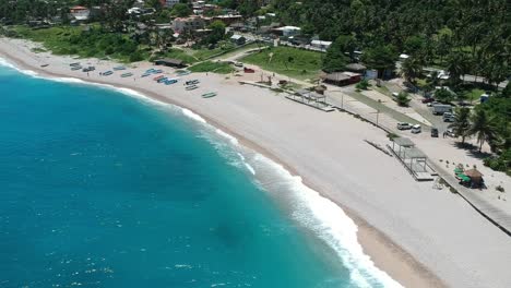 Drone-Descendiendo-Sobre-El-Increíble-Agua-Azul-Del-Caribe-Da-Una-Vista-De-La-Playa-Y-La-Ciudad-De-Los-Patos,-República-Dominicana