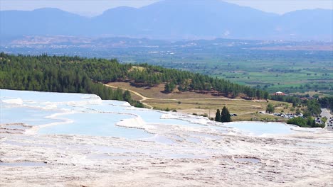 Light-blue-natural-water-pools-and-white-marble-of-the-natural-attraction-Pamukkale-in-Turkey