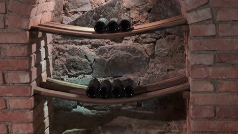 Wine-bottles-in-niche-in-wine-cellar,-brick-and-stone-wall-building