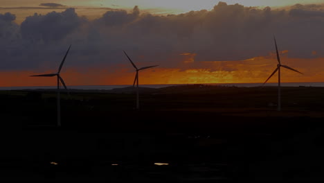 Wind-turbines-in-harmony-with-nature-against-beautiful-colourful-sunsetting-skies,-static-shot