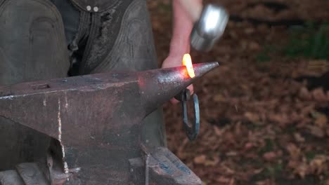 Blacksmith-forging-heart-shaped-iron-on-anvil,-closeup,-nobody