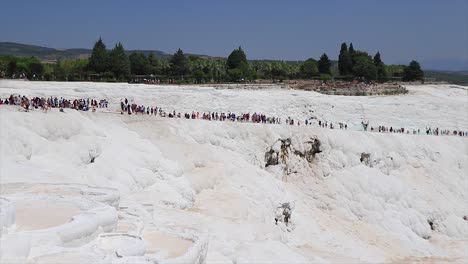 Big-crowd-of-people-walking-on-the-white-marble-at-the-natural-landmark-of-Pamukkale-in-Turkey