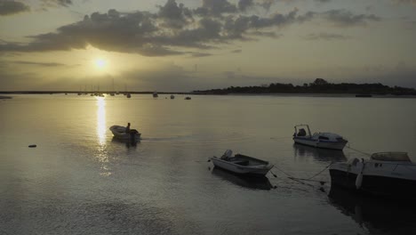 Flusssonne-Am-Morgen-Mit-Fischereibeginn-Und-Silhouettenbooten-Im-Hintergrund-In-Tavira-Portugal