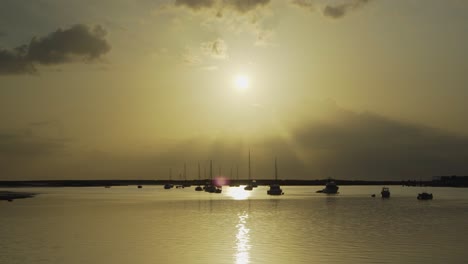 Flusssonne-Am-Morgen-Mit-Silhouettenbooten,-Die-In-Tavira-Portugal-Schwimmen