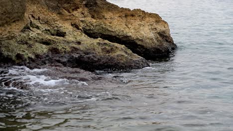 Calm-waves-hiting-rocks-on-a-gloomy-day-in-slow-motion