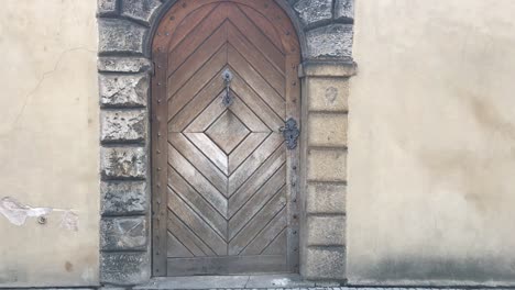 Medieval-wooden-door-entry-with-wrought-iron-ornaments-in-castle-district-in-Prague