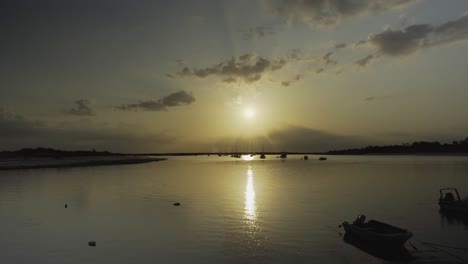 Flusssonne-Am-Morgen-Mit-Silhouettenbooten,-Die-Tavira-Portugal-Schwimmen