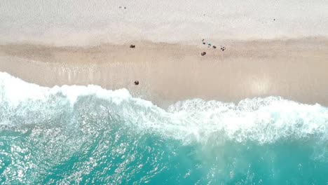 High,-wide-aerial-look-down-view-of-waves-crashing-on-a-white-Caribbean-beach-in-the-Dominican-Republic
