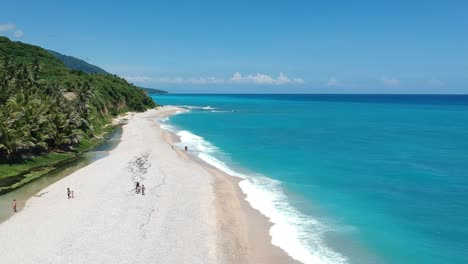 A-narrow-pebble-beach-between-the-deep-blue-Caribbean-Sea-and-a-fresh-water-spring-fed-river-on-the-coast-of-the-Dominican-Republic-in-Los-Patos