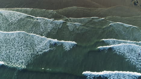 Arial-shot-of-coastal-waves-moving-up-the-frame