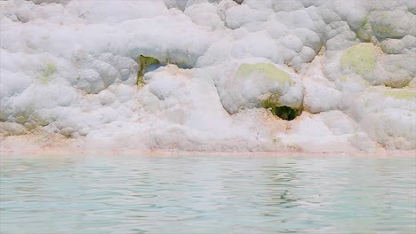 Natural-pool-filled-with-water-and-marble-at-the-natural-landmark-Pamukkale-in-Turkey