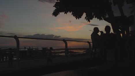 Silhouette-Of-Men-Drinking-Beside-The-Beach-With-A-Sunset-View