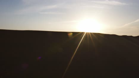 Magical-reveal-shot-of-dreamy-sunrise-over-Abu-Dhabi-barren-sandy-desert