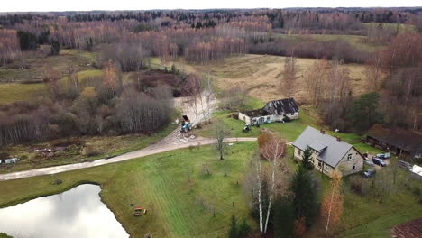 Luftaufnahmen-Vom-Langsamen-Überfliegen-Eines-Alten-Einfamilienhauses-Zwischen-Wäldern-In-Der-Landschaft-Lettlands