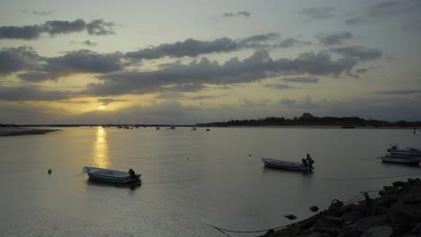 Flusssonne-Am-Morgen-Mit-Fischer--Und-Silhouettenbooten-Im-Hintergrund-In-Tavira-Portugal