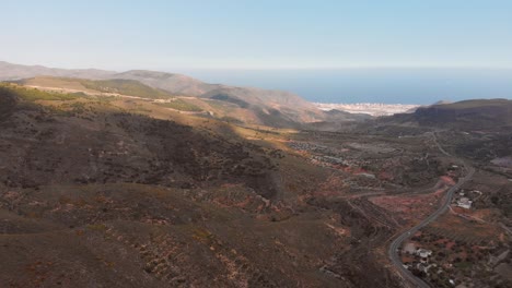 The-mountains-near-Almeria-in-the-south-of-Spain-with-in-the-background-the-greenhouses,-Aerial-shot