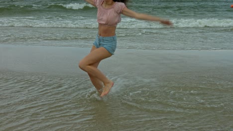 Eine-Frau,-Die-In-Den-Seichten-Wellen-Am-Strand-Tanzt