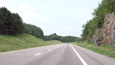Driving-on-a-highway-bordered-with-trees