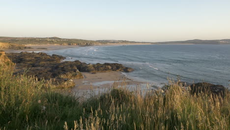 Panoramic-view-of-rolling-waves-and-surrounding-coastline-at-Godrevy,-panning-shot