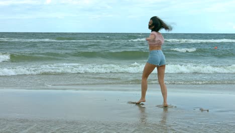 Young-slim-athletic-dancer-is-dancing-on-the-sandy-beach