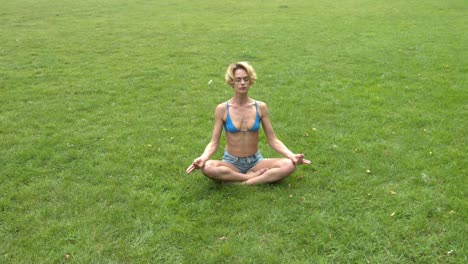 Female-meditate-in-calm-park-in-yoga-lotus-pose