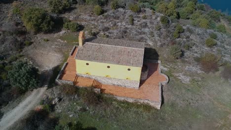 Aerial-shot-orbiting-over-a-small-hermitage-near-a-lake