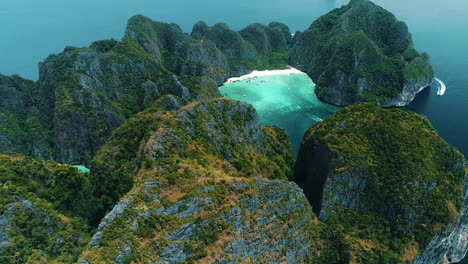 Aerial-view-of-iconic-tropical-turquoise-water-Pileh-Lagoon-surrounded-by-limestone-cliffs,-Phi-Phi-islands,-Thailand
