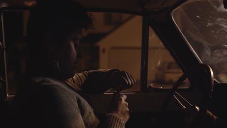Close-up-of-teen-driver-drinking-in-vintage-car-while-pulled-over-by-police-at-night-in-4K