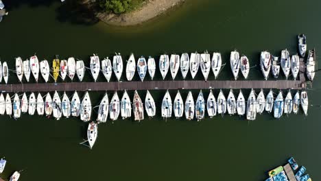 Boats-pier-on-the-lake,-rows-of-sailing-boats-moored-by-a-pier