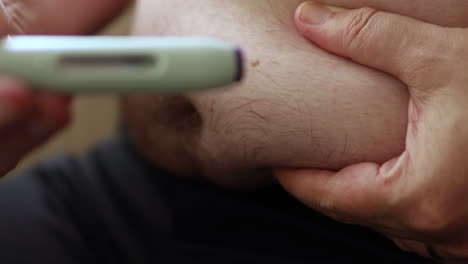 Close-up-of-self-applying-of-medicine-through-a-medical-needle-pen-injecting-the-substance-in-a-fatty-area-of-the-abdomen