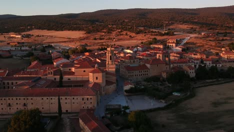 Aerial-view-of-a-monastery-and-the-town-to-which-it-belongs-at-sunset