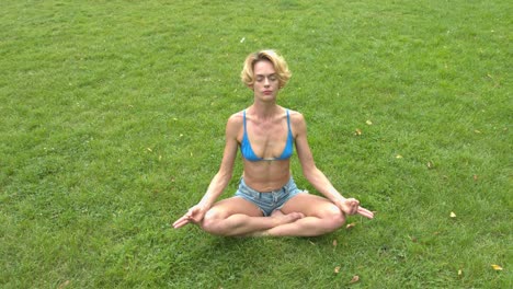 Una-Mujer-Sentada-En-La-Suave-Hierba-Verde-Meditando