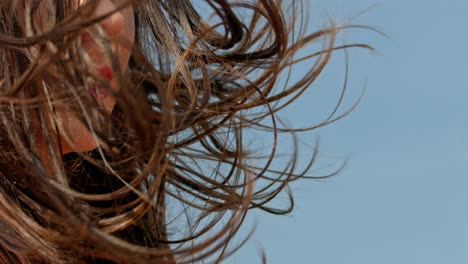 Closeup-view-of-a-young-beautiful-woman-showing-her-brown-luscious-hair-flowing-along-with-the-wind