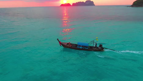 Eine-Niedrige-Luftaufnahme-Eines-Mädchens-Im-Thailändischen-Longtail-Boot-Im-Sonnenuntergang