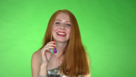A-young-beautiful-woman-all-dressed-up-laughing-away-and-playing-with-a-balloon-whistle