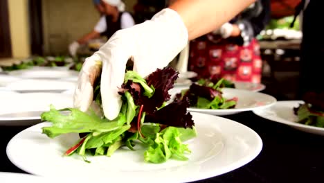 Hands-putting-leaves-for-salad-at-a-banquet