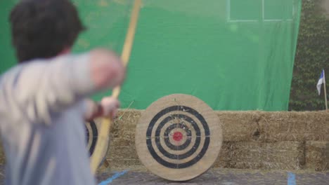 Slow-Motion-shot-of-a-person-shooting-an-arrow-with-a-medieval-wooden-bow-at-a-practice-target