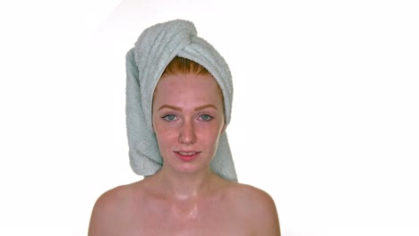 Young-redhead-woman-with-towel-on-head-smiling-to-camera