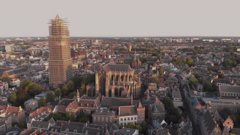 Vista-Aérea-Del-Centro-De-La-Ciudad-De-La-Ciudad-Medieval-Holandesa-De-Utrecht-En-Los-Países-Bajos-Al-Amanecer,-Revelando-La-Torre-De-La-Catedral-En-Andamios