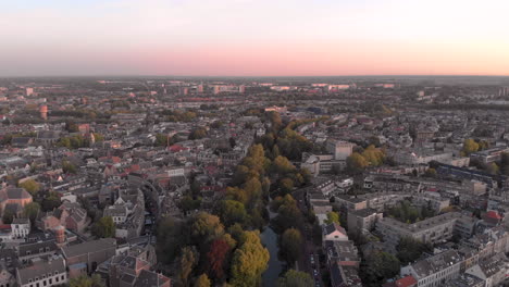 Aerial-view-of-the-medieval-Dutch-city-centre-of-Utrecht-following-one-of-its-canals-at-early-morning-sunrise