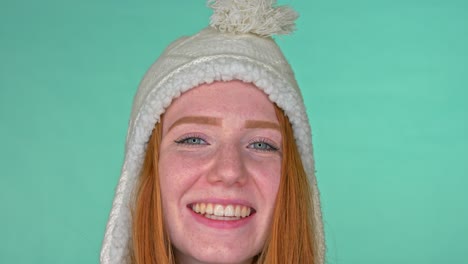 Smiling-redhead-woman-with-blue-eyes-and-warm-winter-hat-on-head