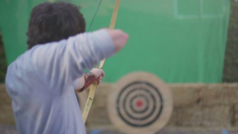 Slow-Motion-shot-of-a-man-shooting-an-arrow-with-a-medieval-wooden-bow-at-a-practice-target