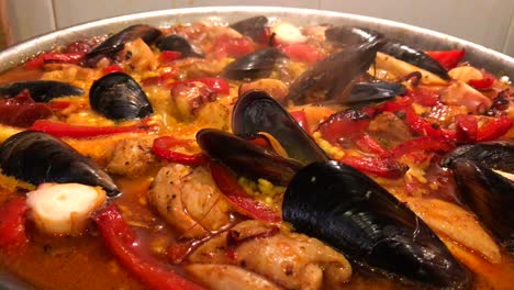 Close-up-of-home-made-paella-dish-with-prawns,-mussels-and-fish,-traditional-Spanish-seafood-cooking