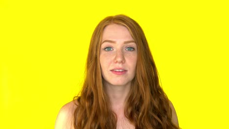 Shocking-redhead-woman-screaming-with-open-mouth-on-yellow-background