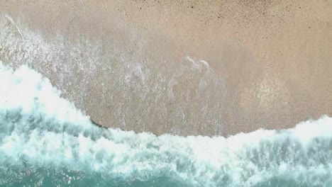Ascending-aerial-view-from-drone-over-waves-breaking-on-a-Caribbean-beach