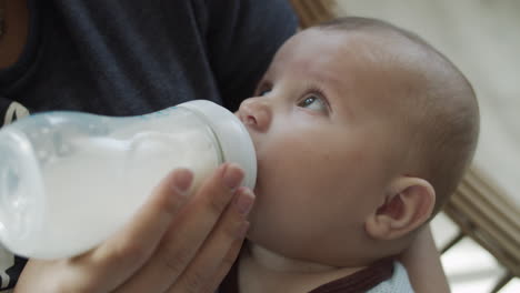 Nahaufnahme-Eines-Kleinen-Jungen-Während-Der-Fütterung-Aus-Einer-Flasche-Mit-Babynahrung