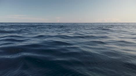 View-of-calm-ocean-water-surface-with-small-waves-and-empty-horizon,-slow-motion