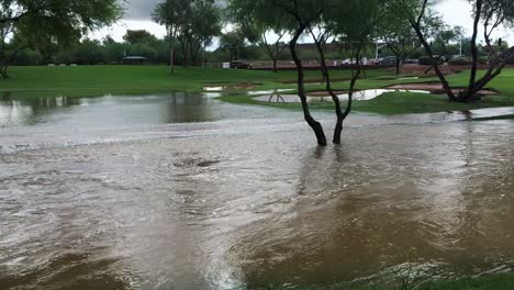 The-camera-follows-the-floodwaters-in-the-Indian-Bend-Wash-Scottsdale,-Arizona