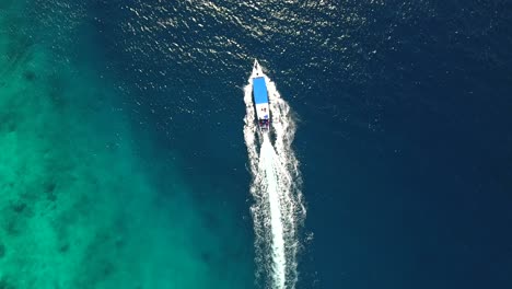 Aerial-top-down-view-of-a-fast-boat-traveling-off-the-shore-of-Gili-Trawangan