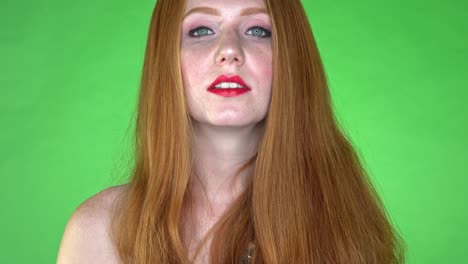 A-close-up-of-a-woman's-face,-showing-neutral-expression,-on-a-seamless-green-studio-background-green-screen